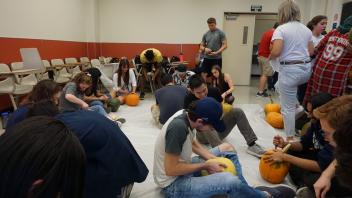 Members carving pumpkins