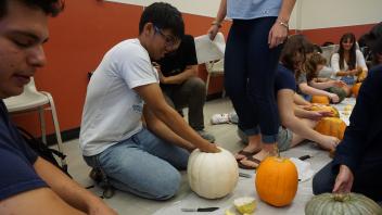 Joseph Quesada scooping the insides of a pumpkin!